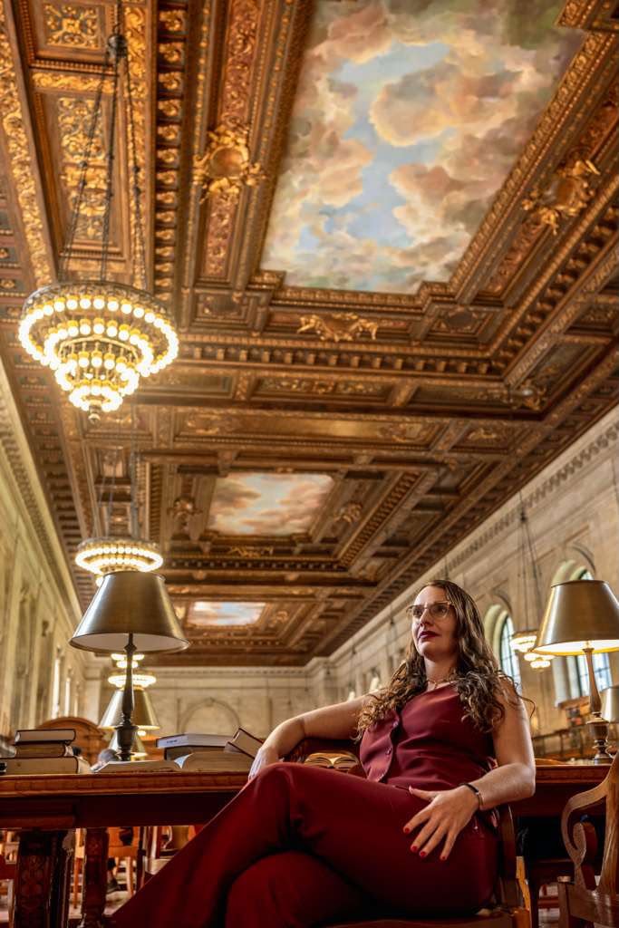 Tam Gryn seated under the library ceiling mural